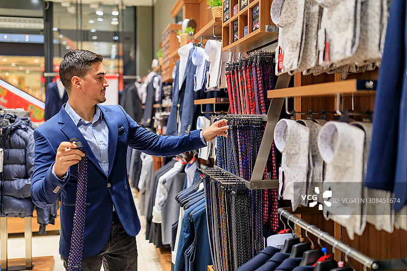 在商店里买衣服的英俊年轻人图片素材