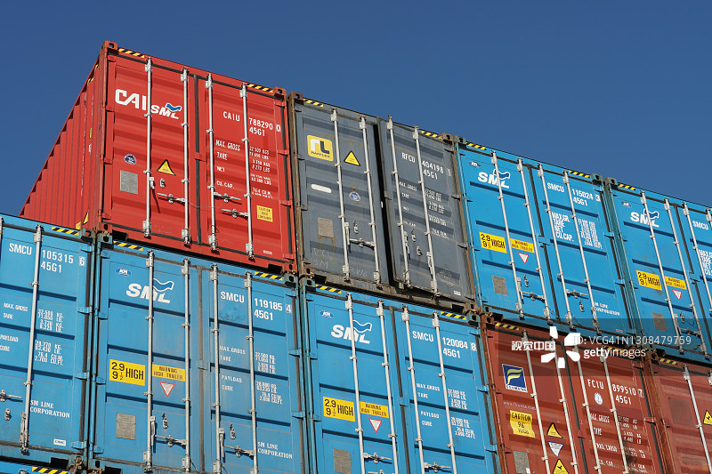 船上堆叠的多色集装箱，蓝色天空背景图片素材