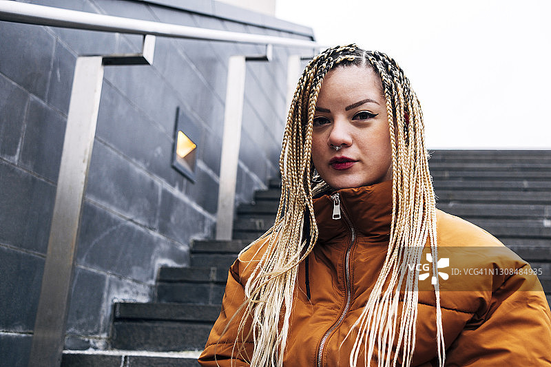 站在楼梯上凝视的穿夹克年轻女人图片素材