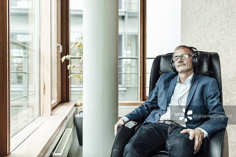 商人在办公室按摩椅上听音乐图片素材