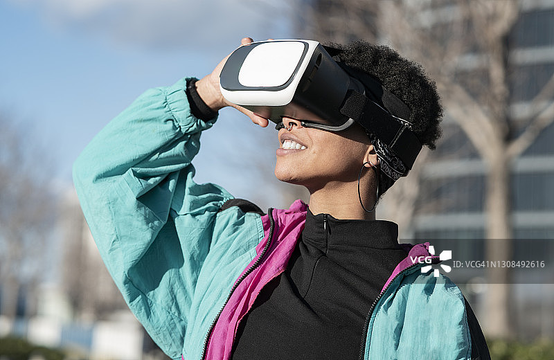 快乐的女人在城市里戴着VR头显图片素材