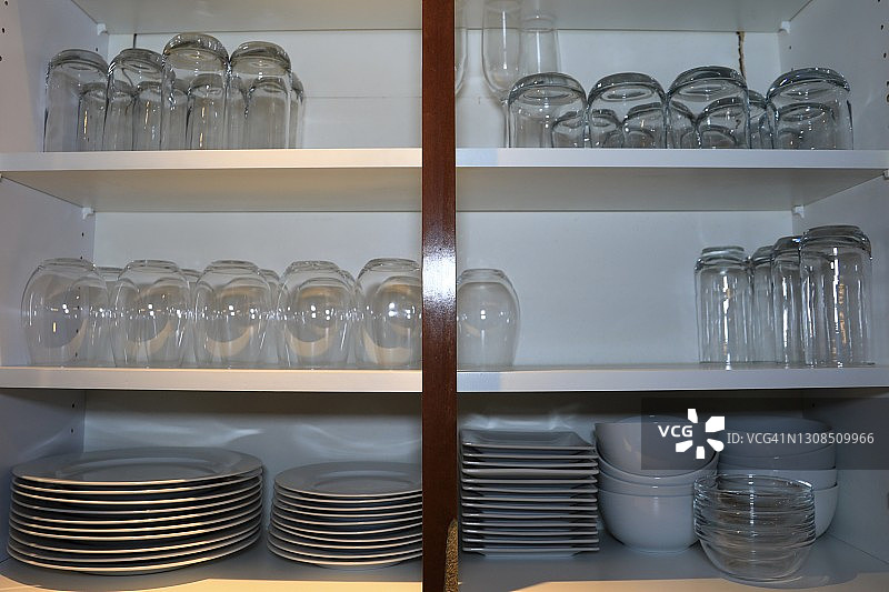 厨房碗柜里的干净碗碟和玻璃杯图片素材
