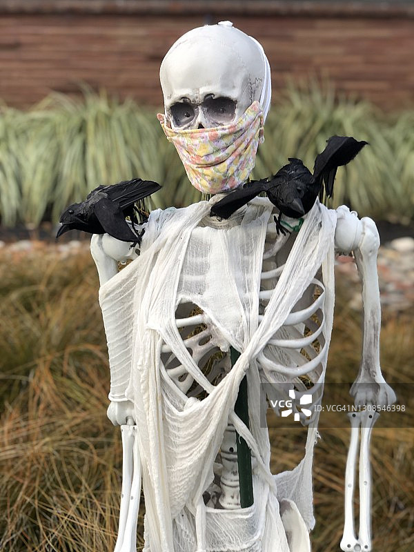 戴着防护口罩的万圣节骷髅装饰品图片素材