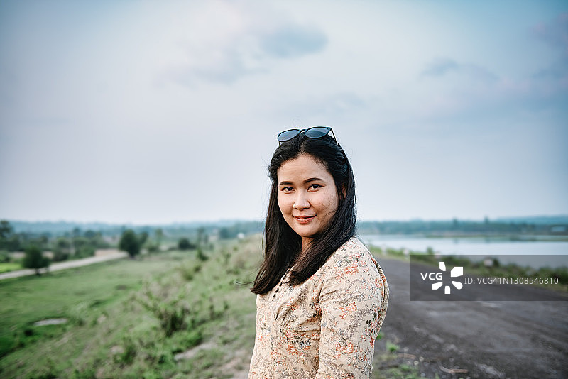 站在户外田野背景前的亚洲女性图片素材