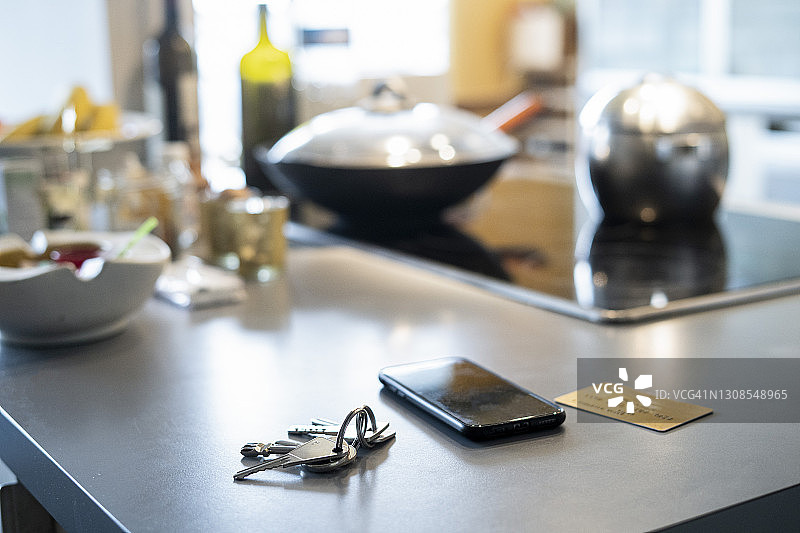 厨房台面上智能手机、钥匙和信用卡特写图片素材