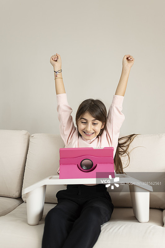 小女孩在家使用塑料桌上的平板电脑图片素材
