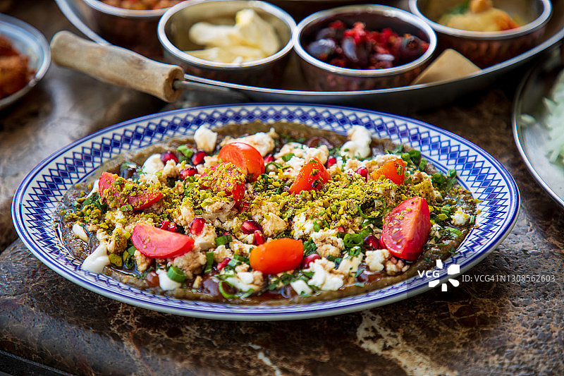 烤茄子和枣沙拉，配奶酪、番茄、石榴糖蜜和开心果图片素材