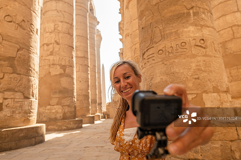 金发女人在寺庙内使用运动相机自拍图片素材