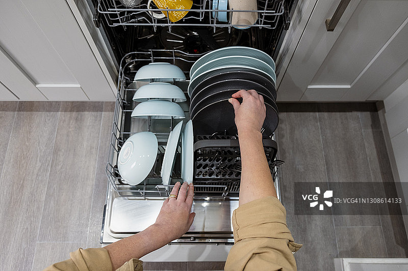 女子清空洗碗机的视角图片素材