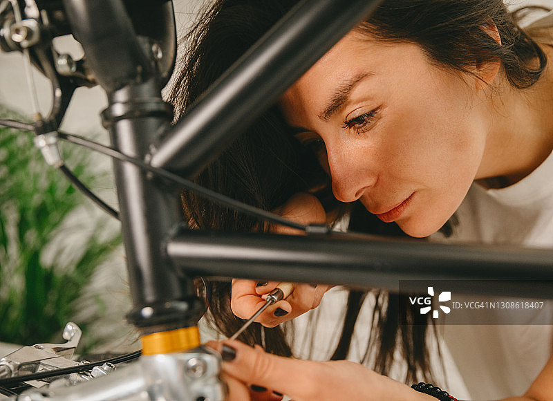 年轻女性修理自行车图片素材