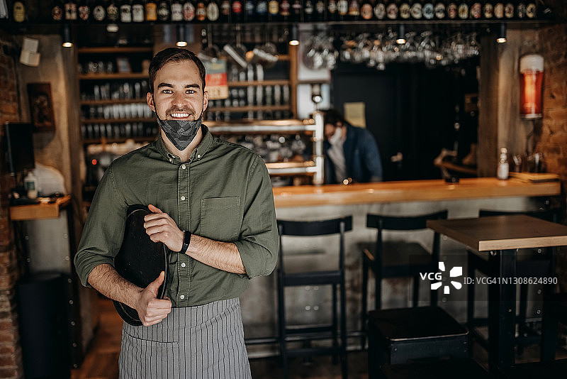 咖啡店里戴口罩的年轻服务员肖像图片素材