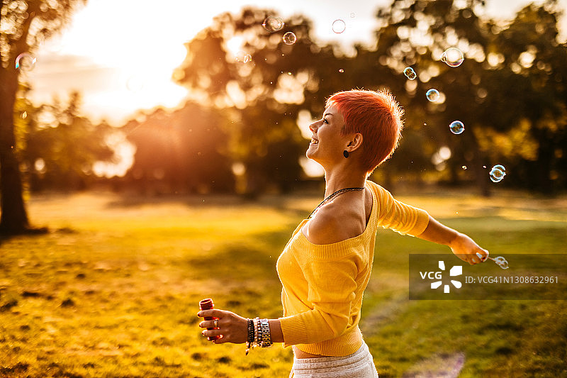 在公园里吹泡泡的短发女人图片素材