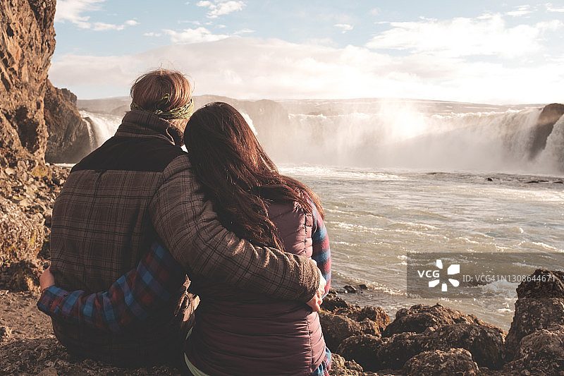 年轻夫妇在瀑布前拥抱图片素材