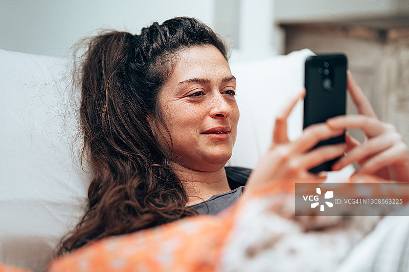 在床上发短信的女人图片素材