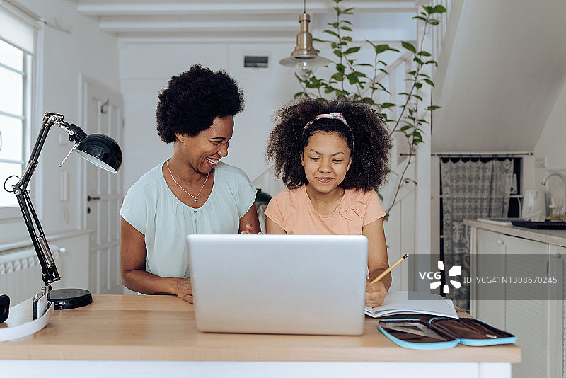 非裔美国妇女在线工作并辅导女儿图片素材