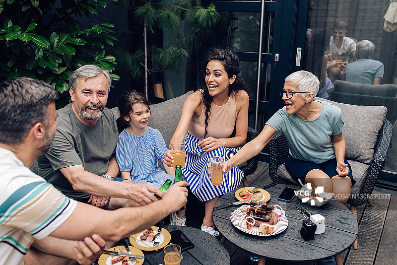 幸福的一家人在后院星期日聚会时敬酒图片素材