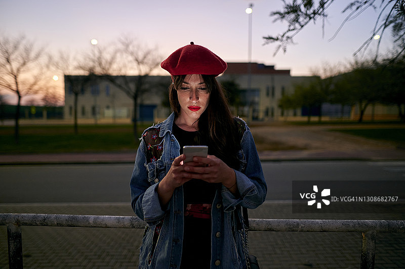 在夜晚的街道上使用手机的女人图片素材
