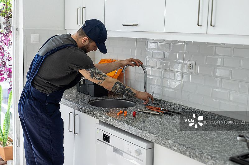 男人修理厨房水槽图片素材