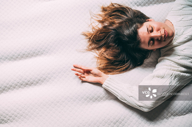 年轻女子躺在床上图片素材