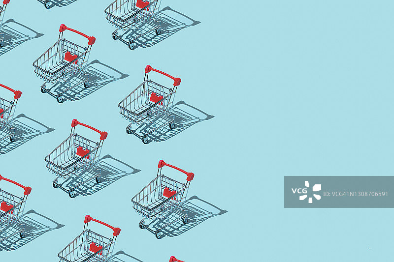 蓝色背景上的购物车图案，购物促销概念，扁平俯视，留有复制空间图片素材