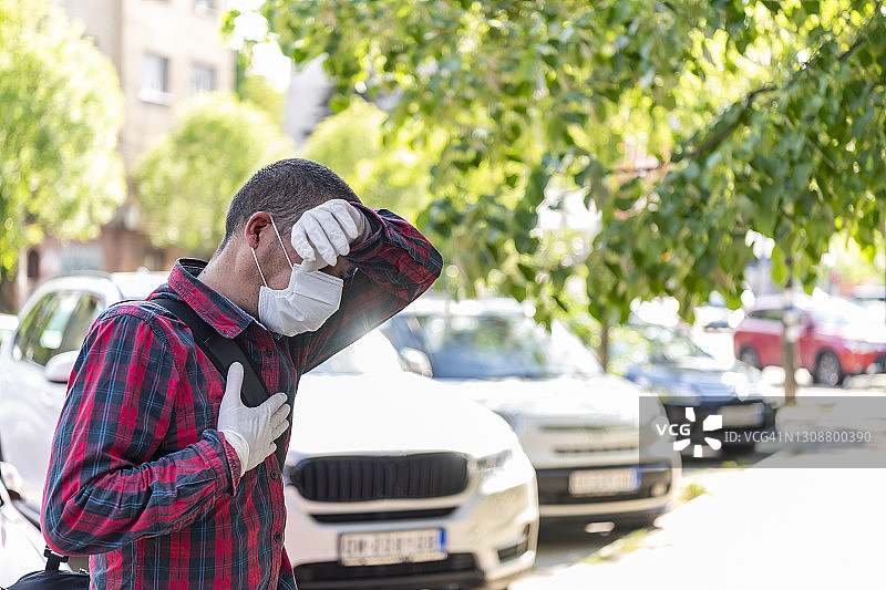 在街上行走并出现冠状病毒症状的商务男人图片素材