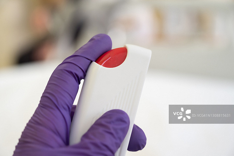 医疗保健人员戴着外科手套按下紧急呼叫控制上的紧急呼叫按钮。新冠病毒时期图片素材