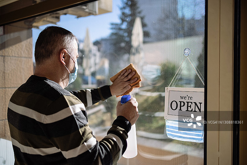 店主在重新开业前清洁和消毒图片素材