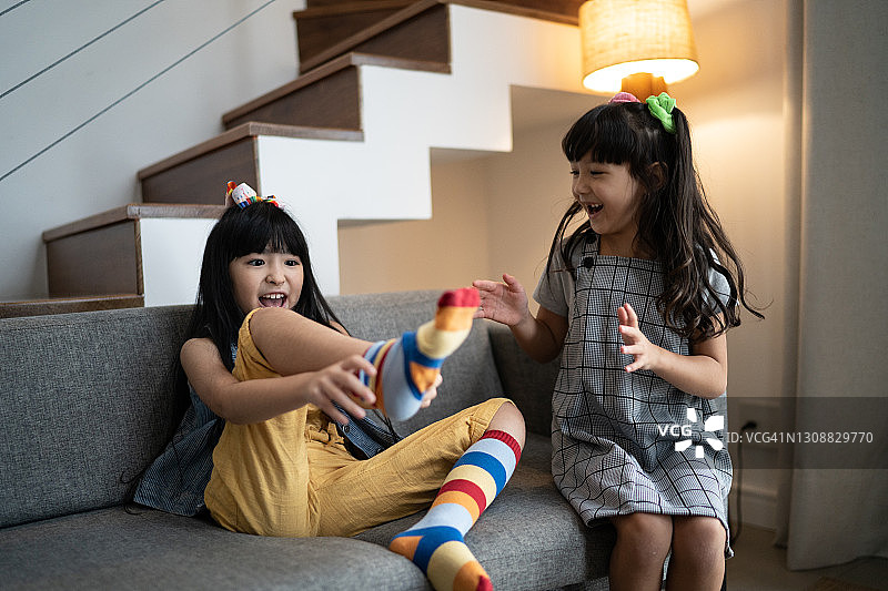 快乐的姐妹在家穿彩色袜子图片素材