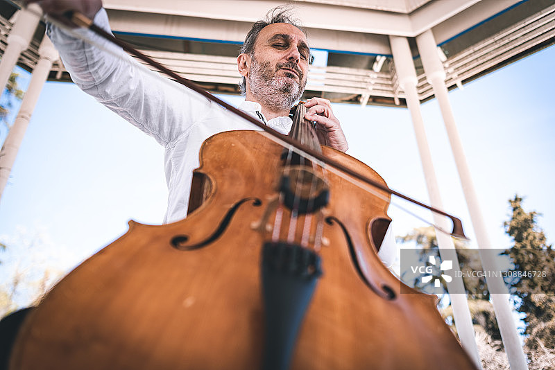 在公园里演奏大提琴的老人图片素材