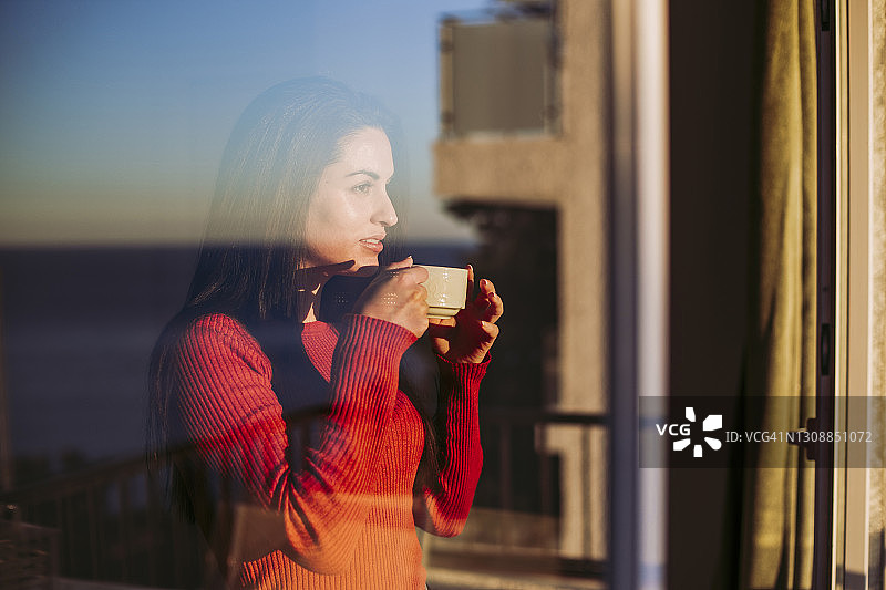 在家靠窗喝咖啡沉思的女人图片素材