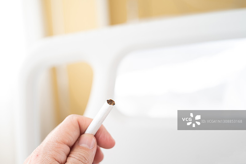男人在病床前手持香烟图片素材