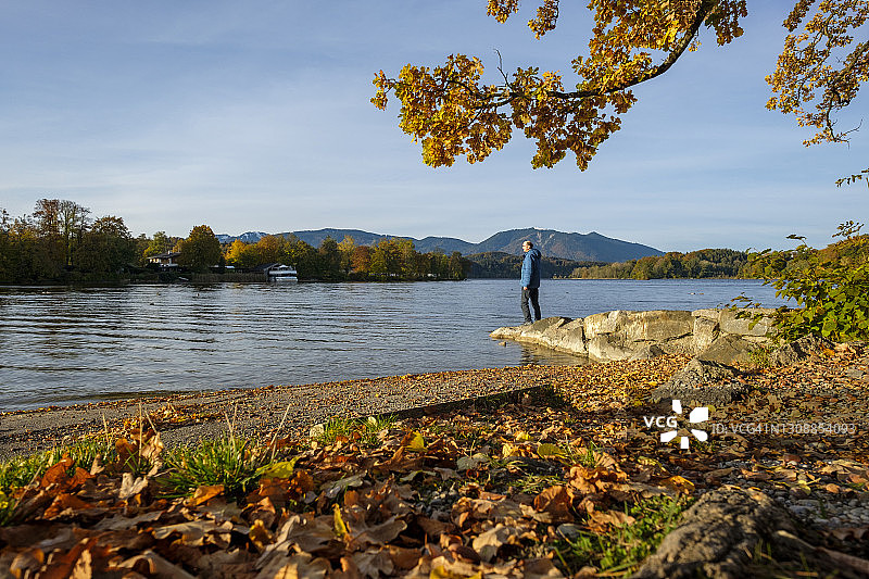 站在湖岸岩石上的男人图片素材