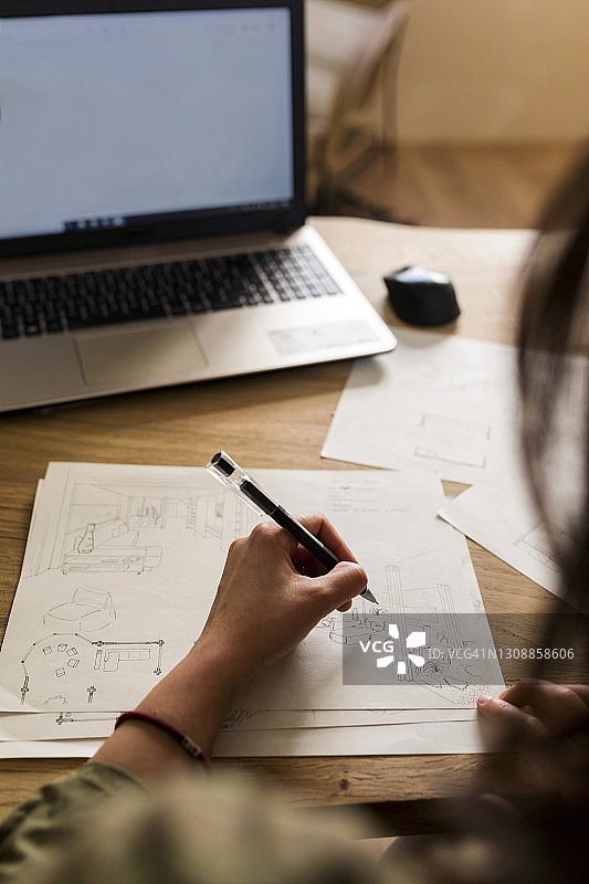 女木匠在工作间用笔记本电脑在纸上做设计图片素材