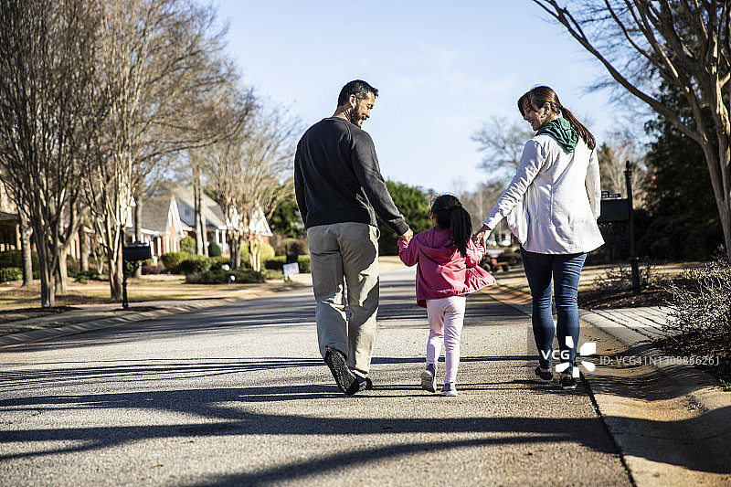 一家三口在郊区社区散步图片素材