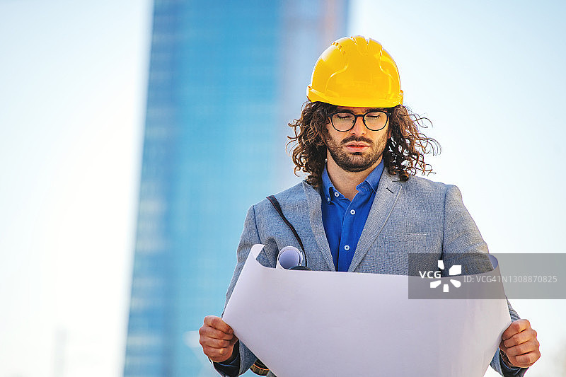 在建筑物前戴防护头盔的建筑师图片素材