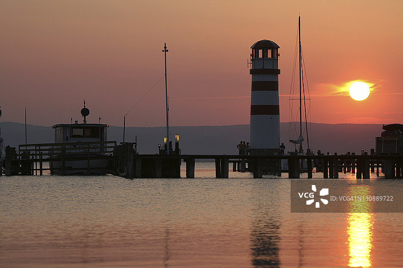 奥地利布尔根兰州诺伊锡德尔湖波德斯多夫的灯塔日落景色图片素材