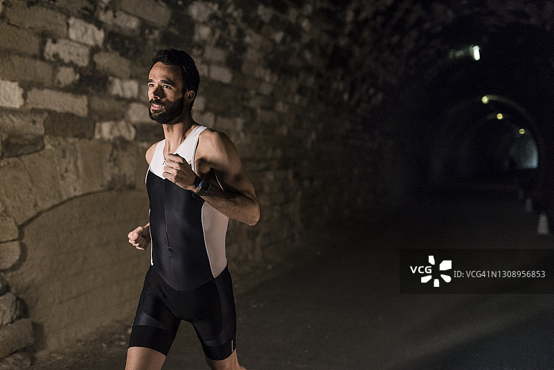 在黑暗隧道中训练的跑步者图片素材