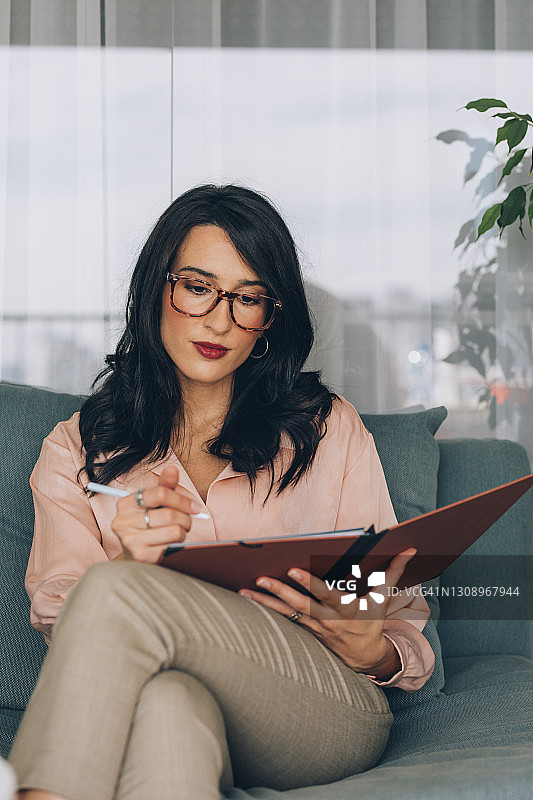 在工作中阅读文件的女商人图片素材