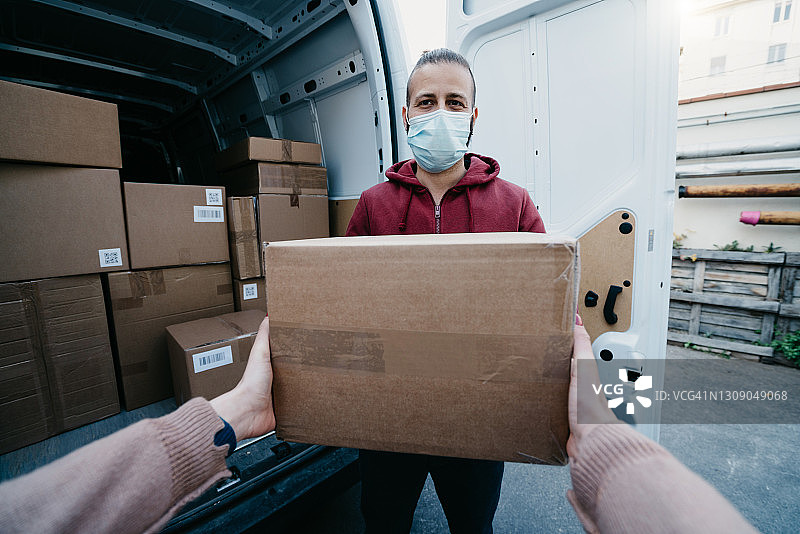女子从送货员手中接过包裹的主观视角图片素材