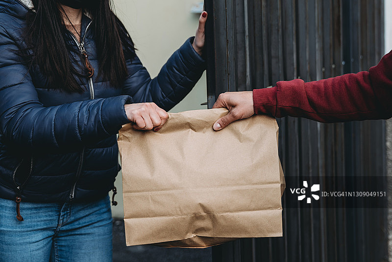 快递员正在给一位女士送午餐盒——特写图片素材