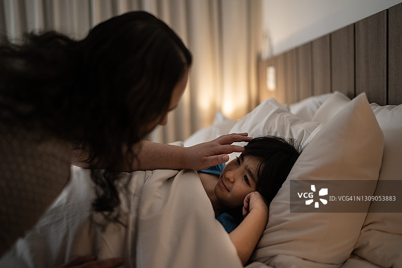 夜晚，母亲哄女儿入睡图片素材