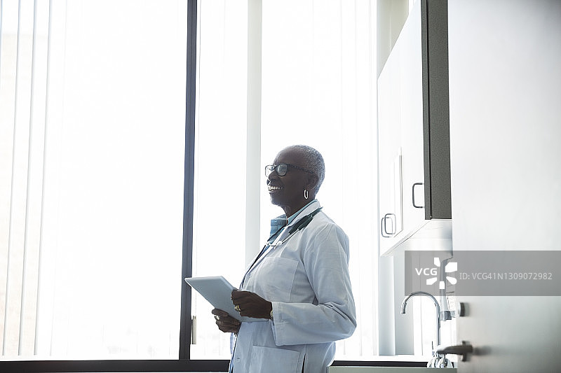 微笑的女医生在医院工作时使用数位板图片素材