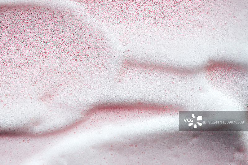 玫瑰背景上的白色泡沫纹理。自爱是年度潮流程序。带有复制空间的化妆品banner图片素材