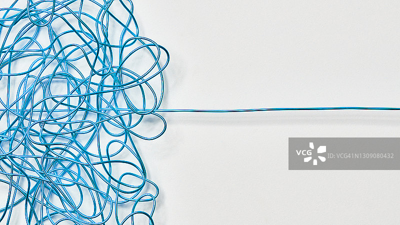 缠绕的蓝色电线在白色表面上伸直图片素材