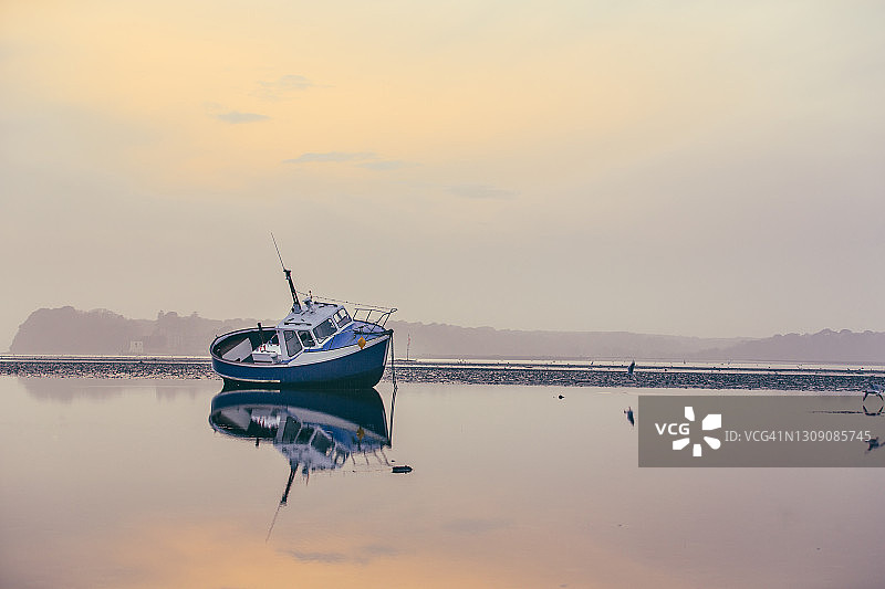 退潮时夕阳下的小渔船海滩图片素材