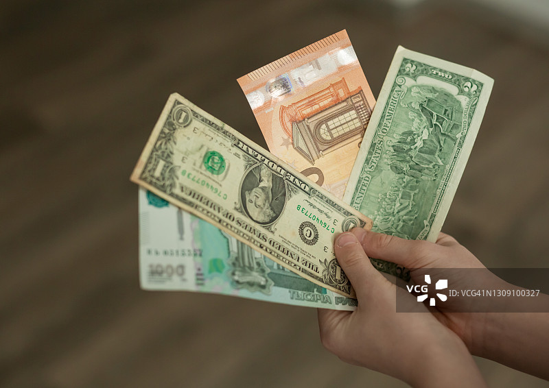 手中的纸币，美元、欧元和卢布钞票特写图片素材
