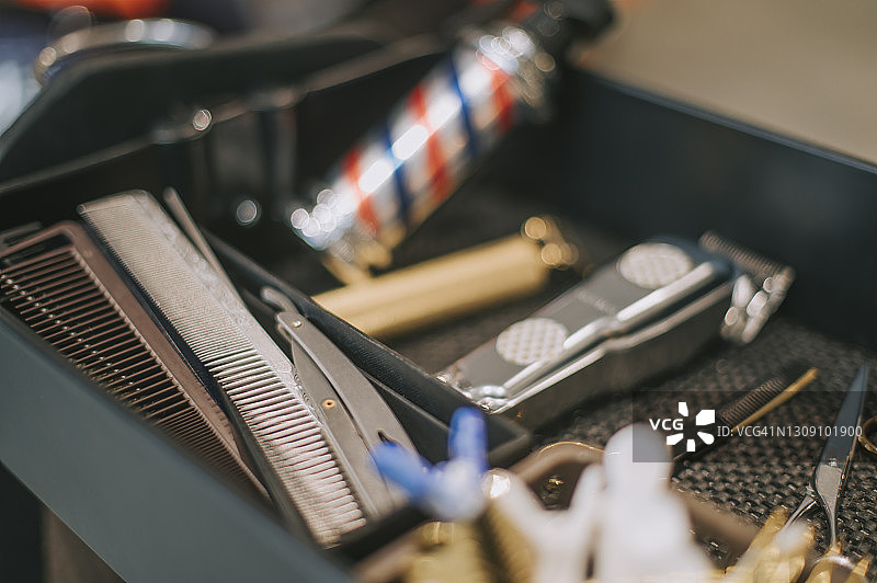 托盘上的理发工具：剪刀、理发器、乳液瓶、梳子、夹子、剃须刀片图片素材