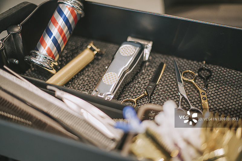 托盘上的理发工具：剪刀、理发器、乳液瓶、梳子、夹子、剃须刀片图片素材