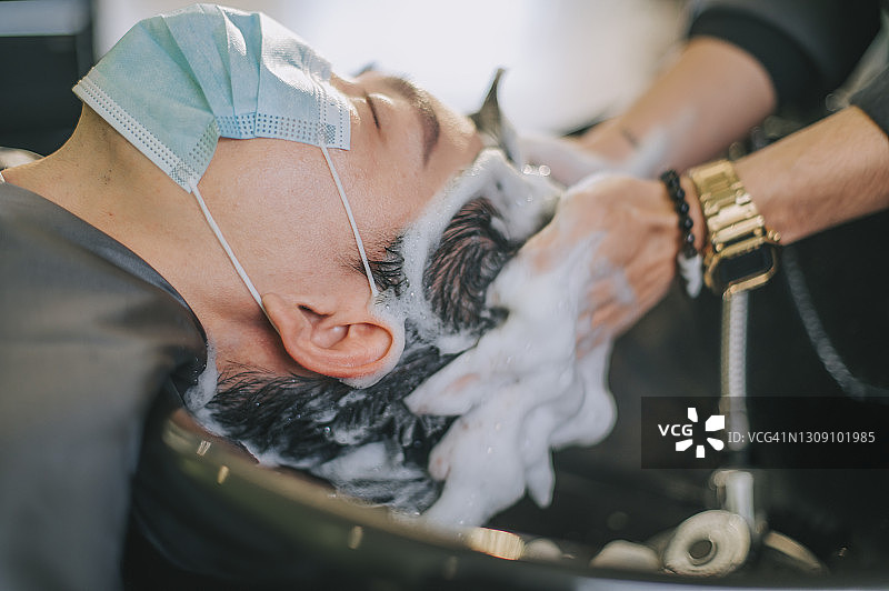 中国男子在理发店享受洗发服务图片素材