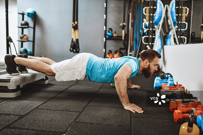 留着胡子的男运动员练习踏步撑图片素材